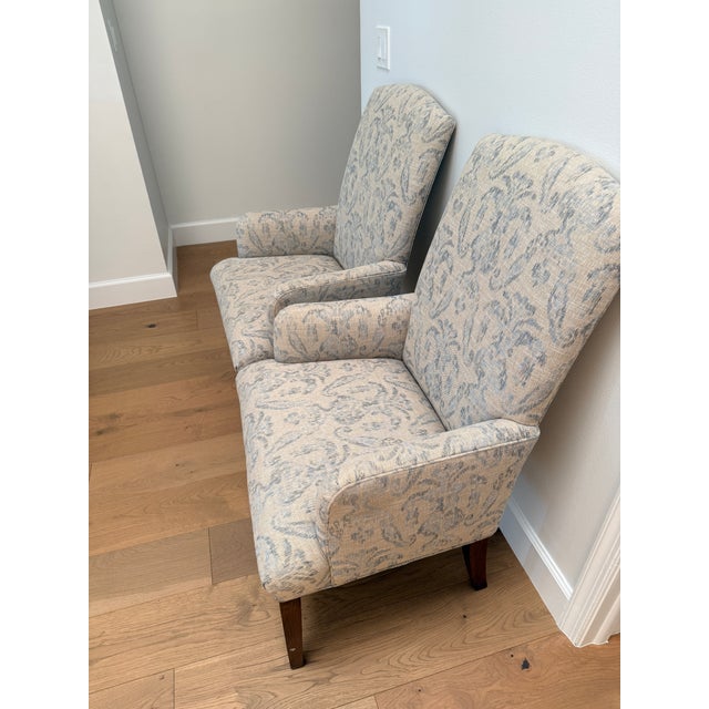 Beautiful upholstered accent armchairs in a versatile neutral beige and taupe tone with a hit of blue accent. These two...