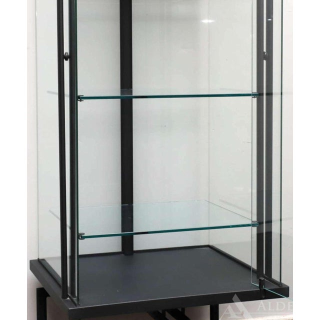 This is a vintage black metal framed glass encased display cabinet. It is very(!) heavy and sturdy and has a glass door in...