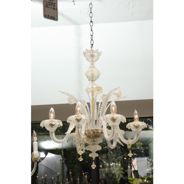 Here we have an ornate Venetian glass chandelier with elaborate floral ornamentation and ribbed glass arms. Handcrafted...