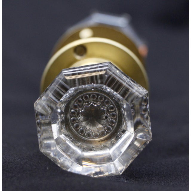 Vintage octagon clear glass door knob set with a star bullet center and brass rosettes. Good condition with appropriate...