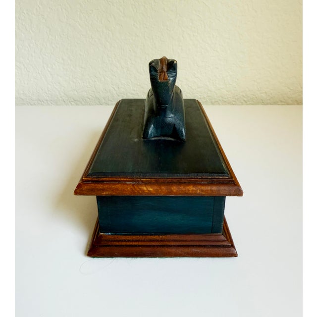 Primitive folk art trinket box with hinged lid, topped with a carved horse handle. Finished in blue and brown stain....