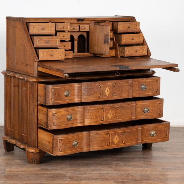 The warm patina of the aged wood glows with life in this lovely rococo secretary or bureau with striking inlaid double...