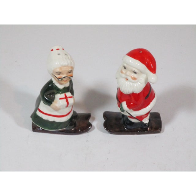 Vintage set of hand painted Santa and Mrs. Claus salt and pepper shakers on skies. Add these festive shakers to you...