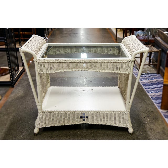 Charming off white wicker console table featuring a woven frame and glass top. Its light, airy design adds texture and...