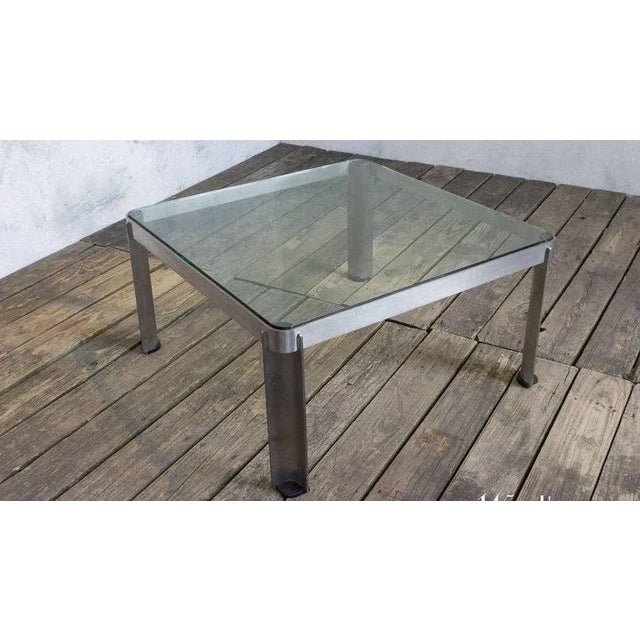 This vintage coffee table, originating from France in the 1980s, features a brushed aluminum and glass construction that...