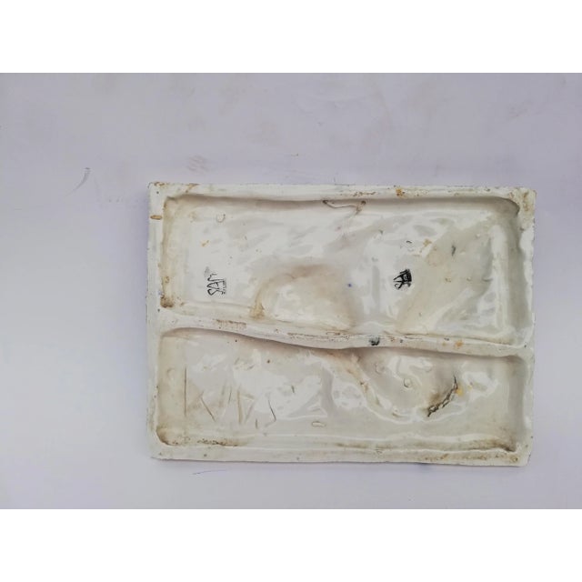 This wall panel depicts a marine scene in relief and is decorated with enamels.