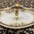 This elegant, boat-shaped porcelain dish features a delicate hand-painted floral motif of pink roses and soft green...