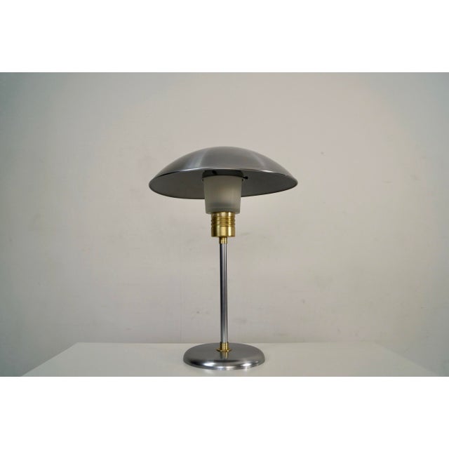 Vintage Art Deco table lamp for sale. It's made of stainless steel with aluminum brass accents, and has a glass diffuser...