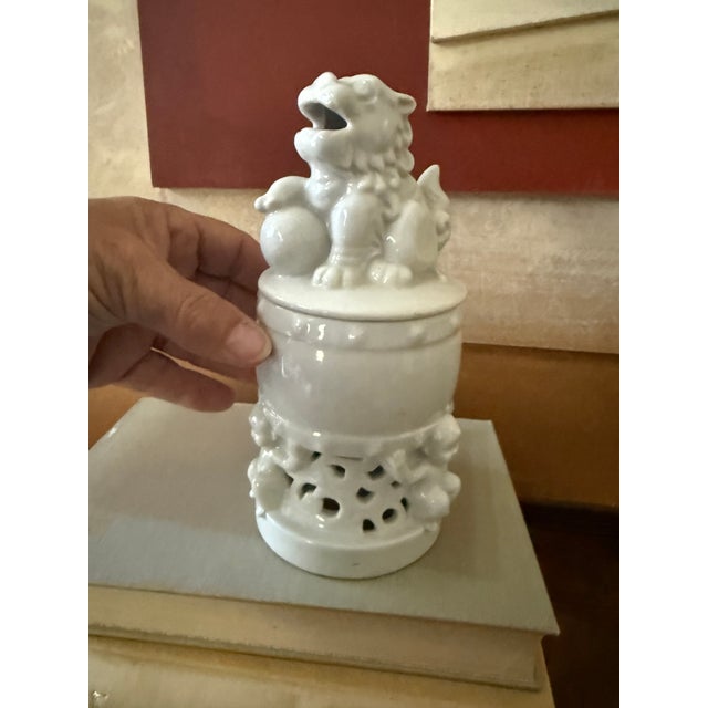 A beautifully sculpted white porcelain covered incense burner topped with a traditional foo dog, also known as a guardian...