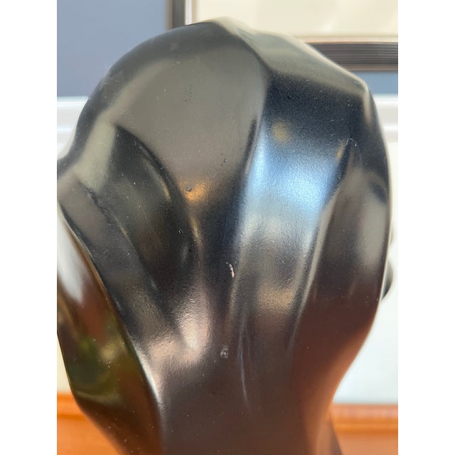 Sculptural black ceramic bust by Harris Potteries, featuring an elongated face, almond-shaped eyes, and sweeping, stylized...