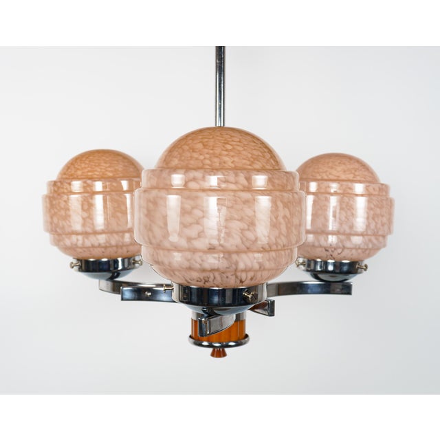 An original vintage 1930s art deco 3-arm chandelier / pendant lamp of chromed steel with ‘butterscotch Bakelite’, or amber...
