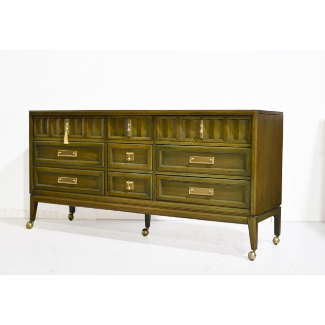 Mid century modern nine-drawer dresser by Stanley Furniture, with a long rectangular case and a warm brown wood finish....