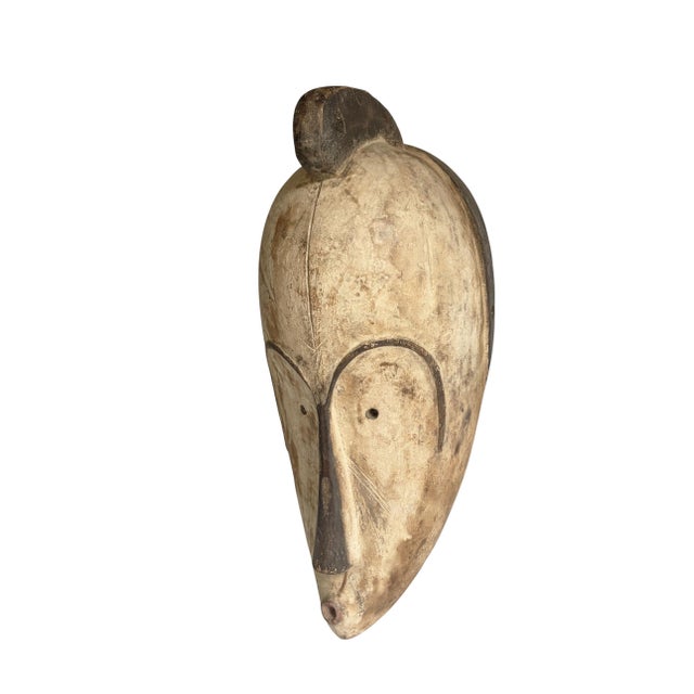 Superb vintage Fang mask carved from a single piece of heavy wood, featuring an elongated heart-shaped face rendered in...