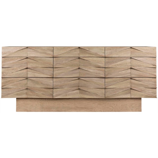 Each of this refined washed walnut sideboard's nine drawers are beautifully embellished with a repeating hand-carved...