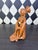 Vintage Indian terracotta sculpture depicting a stylized seated female figure with dramatically elongated arms and legs....