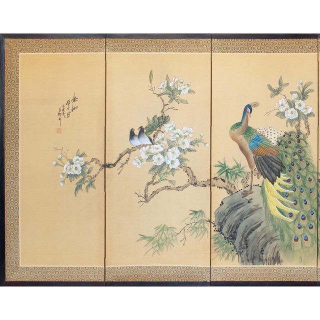 Circa 1970s Chinoiserie Style painted folding silk screen depicts a lovely scene with Peacock and two Doves on blossoming...