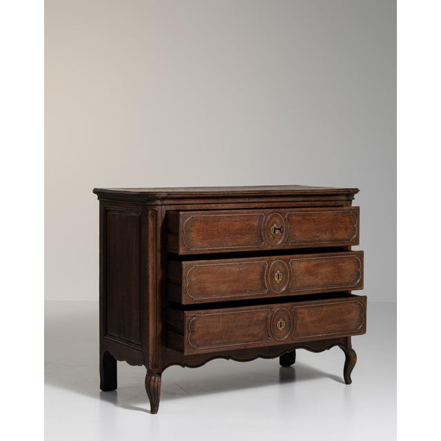 A brown wood, Louis XV-style chest of drawers from the 1800s, made in France. Crafted in wood, the piece retains its...