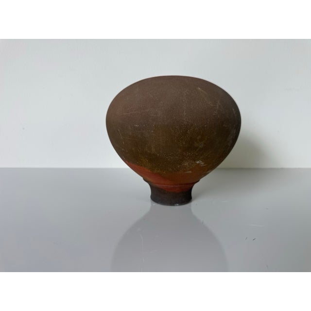 A captivating example of 1980s American studio pottery, this Raku-fired vase presents an earthy, organic presence with a...