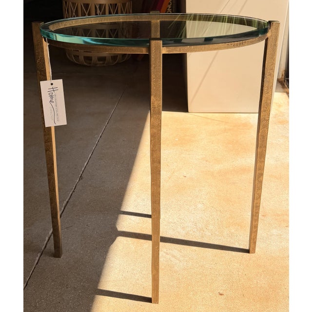 Elevate your space with this elegant contemporary end table, featuring a sleek gold-finished metal frame paired with a...