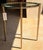 Elevate your space with this elegant contemporary end table, featuring a sleek gold-finished metal frame paired with a...