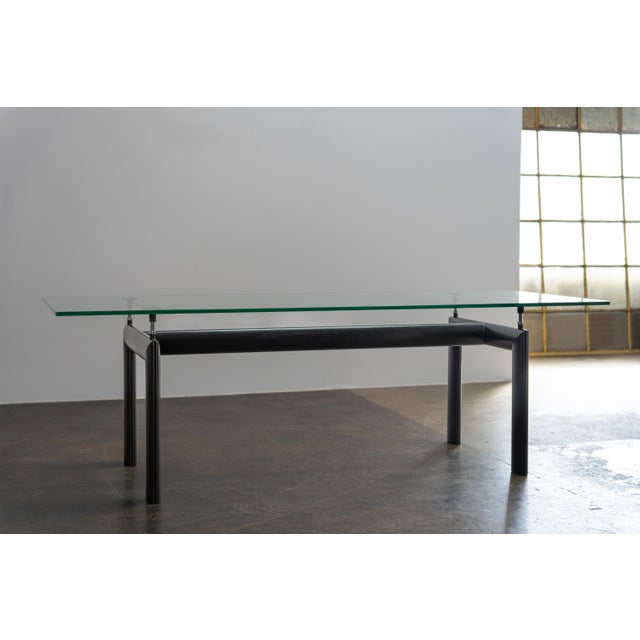 Designed in 1928, the LC6 table features a height-adjustable steel base with a sleek glass top, combining architectural...