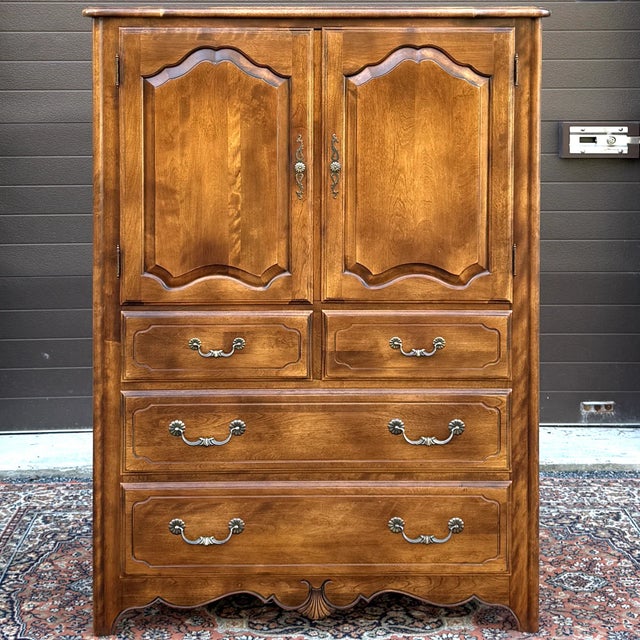 A late 20th century Ethan Allen Country French collection solid birch highboy door dresser having a large 2 door cabinet...
