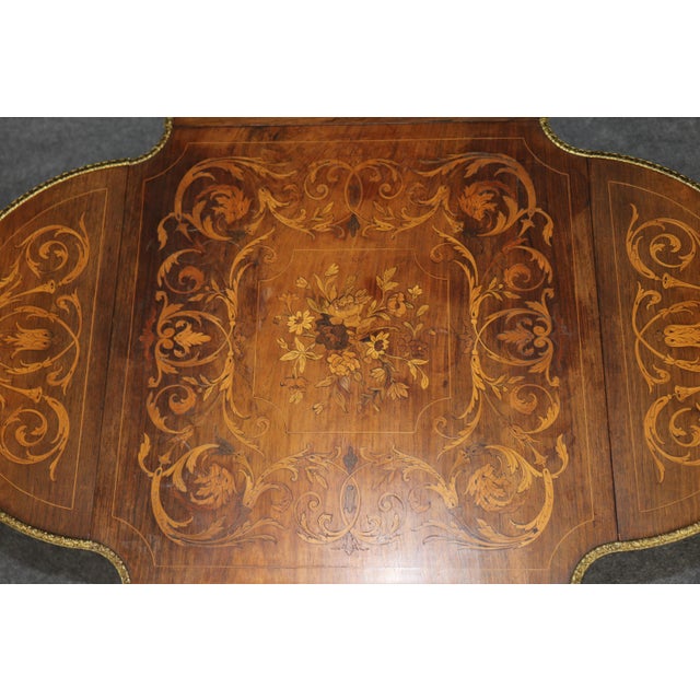 This exceptionally decorative Edwardian walnut and satinwood marquetry occasional table, dating to the late nineteenth or...