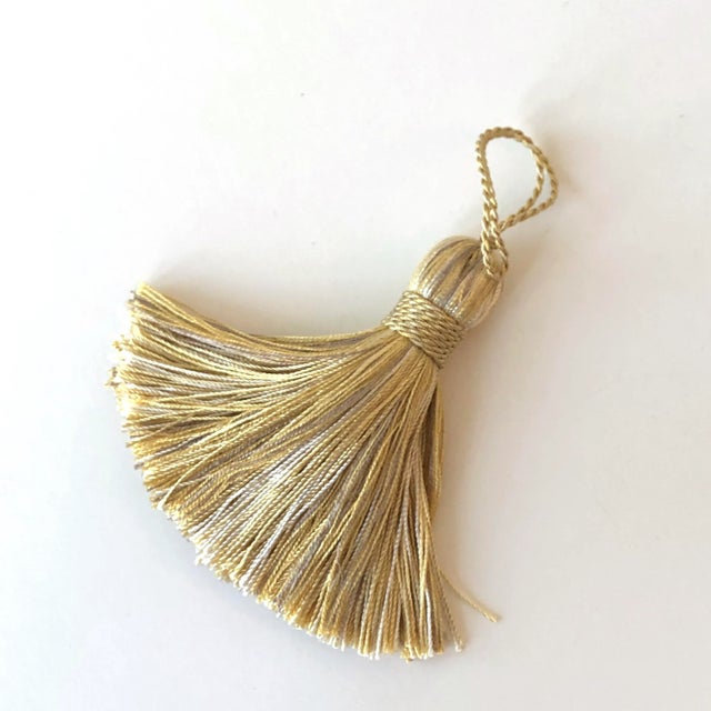 A pair of handmade decorative tassels with a mingle of golds and light neutral colors. Can be sewn into pillow corners,...
