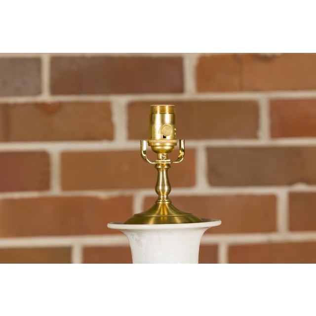 A pair of white porcelain vase shaped table lamps with textured décor and circular lucite bases. Elevate your home's...