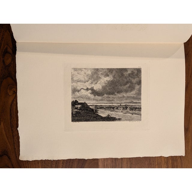 Discover the timeless charm of 19th-century artistry with this exquisite 1873 folio engraving, “Village au Bord d’un...