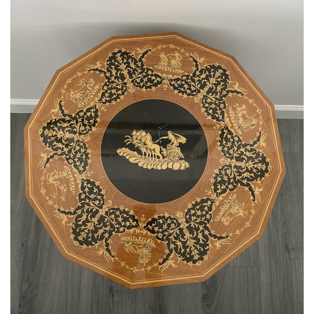Vintage Italian marquetry music box table features intricate, ornate wood inlay on the octagonal top and cabriole-style...