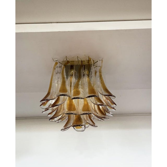 Spectacular ceiling lamp with 32 Murano glass petals (clear with amber spot) in golden painted metal frame. Elegant...