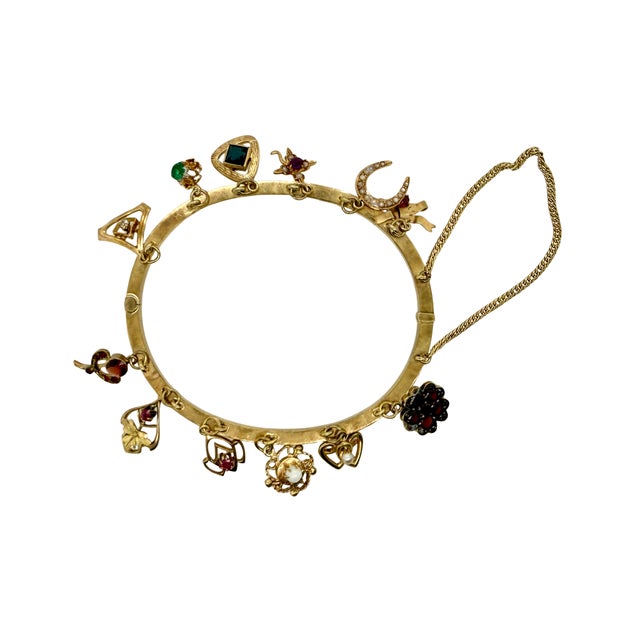 A 19th‑century Victorian charm bangle bracelet incorporating thirteen repurposed stickpin heads in 14K and 10K gold, each...
