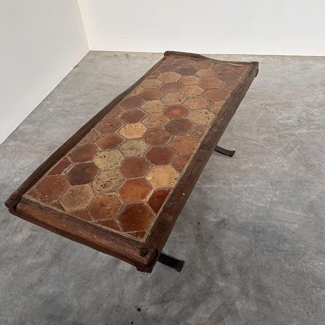 A striking vintage french coffee table combining rustic materials with a strong architectural presence. The rectangular...