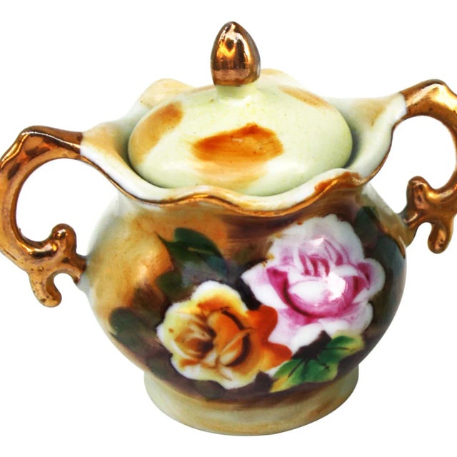 Creamer and sugar dish with hand-painted colorful floral pattern and intricate details. Creamer, 2.5"L x 2"W x 3"H; sugar...
