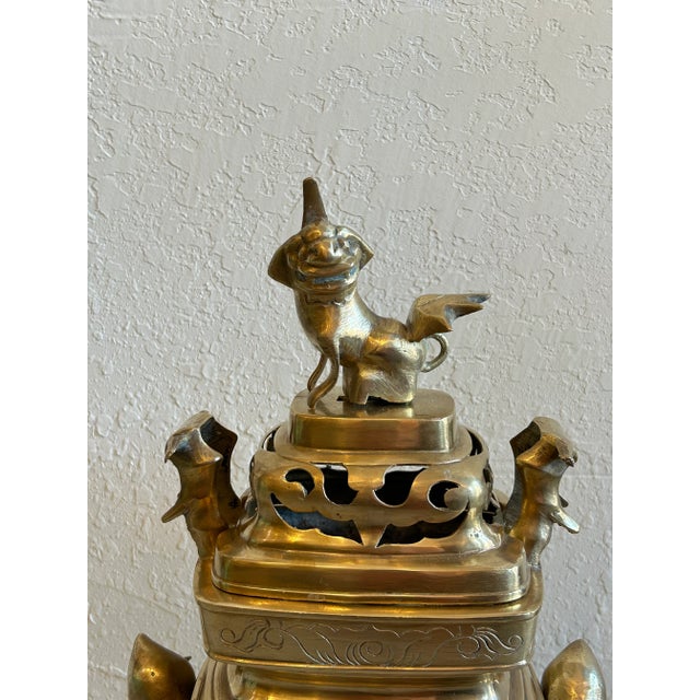 Standout antique Asian sensor, crafted in brass with a foo dog at the top and fruit handles.
