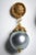 A pair of classically different pearl drop earrings. These feature fine hand-tooling on the earring stud and gold end cap...