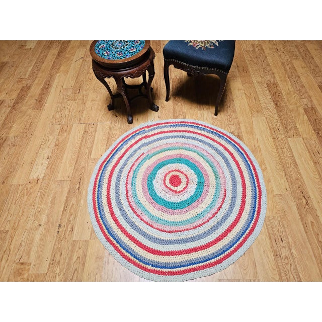 A charming and colorful antique American braided round rug from the second quarter of the 20th century, circa 1940s,...