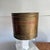 Brass wastebasket or planter with copper band, with hammered finish. Shows signs of age. A rich patina. Some verdigris.
