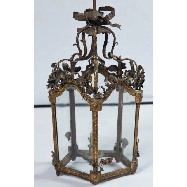 Gilt tin French tole lantern. Lantern height with stem and canopy is 22 inches. Lantern has five panels. Gilt metal. Not...