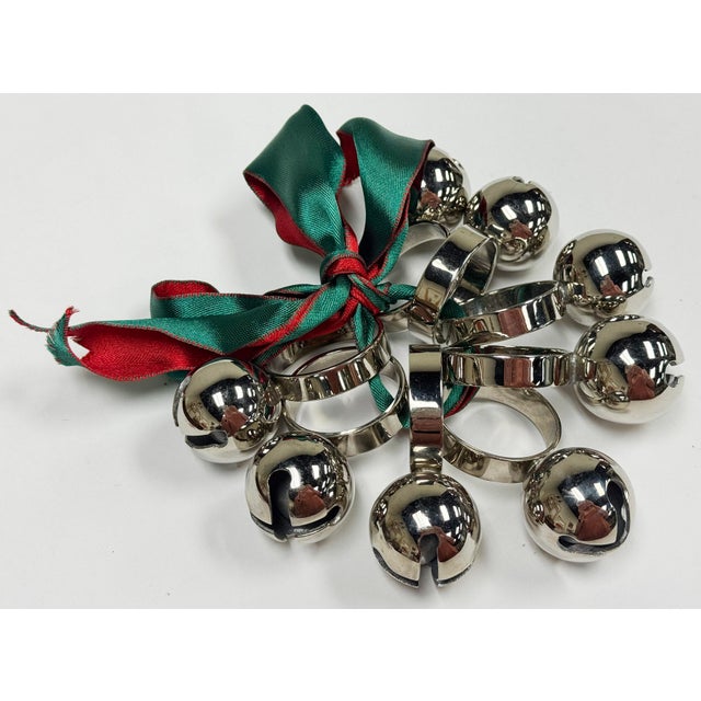 Festive vintage set of eight (8) chrome napkin rings with a jingle bell firmly attached to each ring. Age wear.