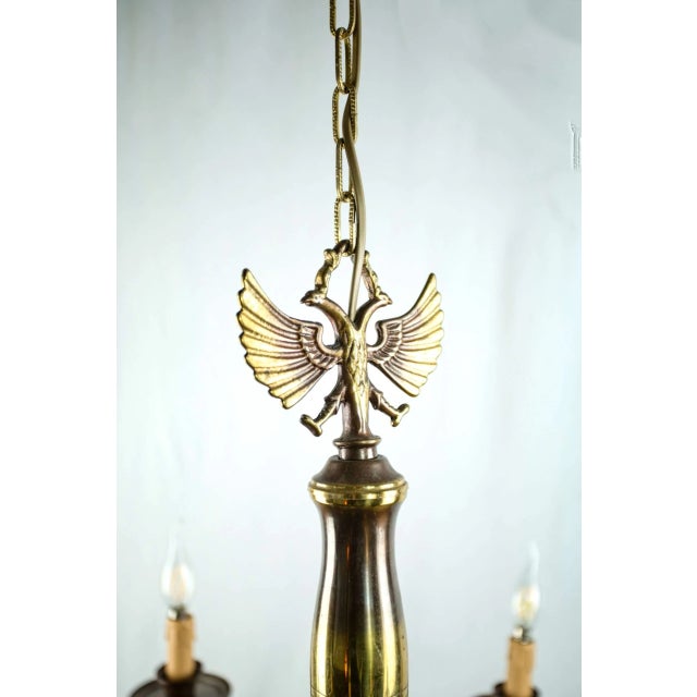 Beautiful eight-armed flemish chandelier made of patinated brass. The upper part of the chandelier is decorated with a...