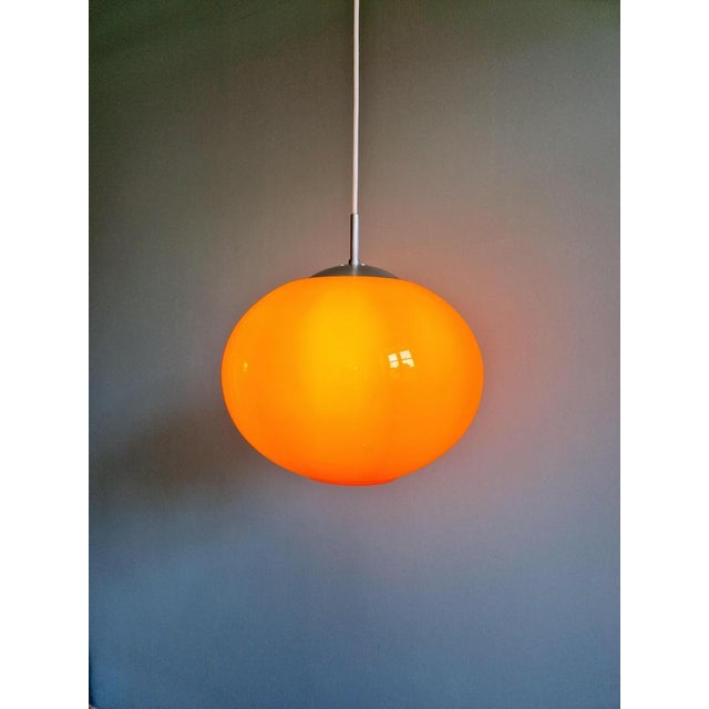 Large Space Age pendant light in orange opaline with a chrome metal frame, 1970s. It has been re-electrified and is...