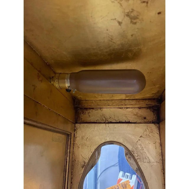 Offered is a vintage black and gold gilt two-piece display cabinet. This piece features three removable glass shelves with...