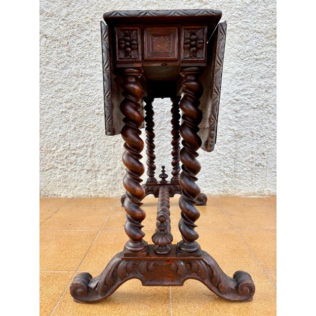 Rare Spanish Baroque Revival drop-leaf table with richly carved details, dating from the early 20th century. The piece...