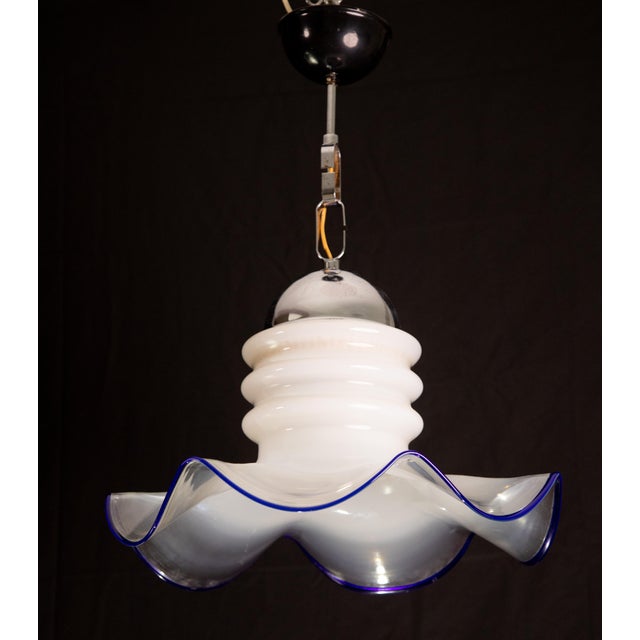 Pretty ceiling lamp made of blown Murano glass in blue and transparent color. Accommodates an E27 bulb, European standard,...
