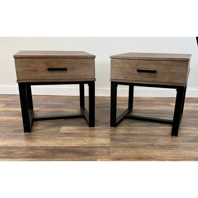 A handsome pair of Lane Home Furnishings end tables combining warm, distressed wood with clean-lined black metal bases....
