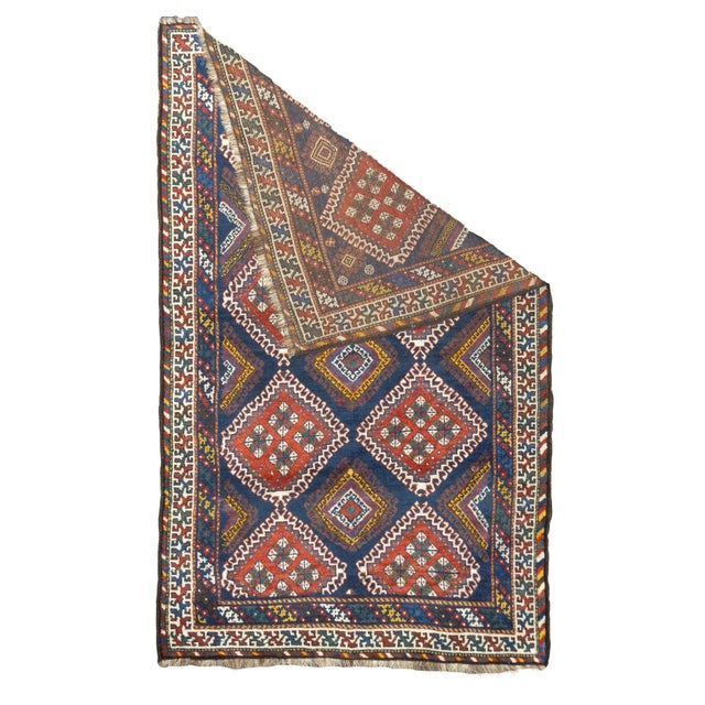 Two columns each of four hooked and nested diamonds in ecru and red define the dark blue field of this SW Persian tribal...