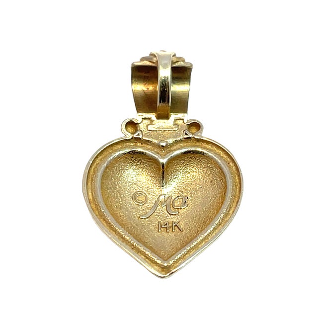 Delicate 14k yellow gold heart-shaped charm pendant featuring a soft matte finish with cut-out leaf motifs. Lightweight at...
