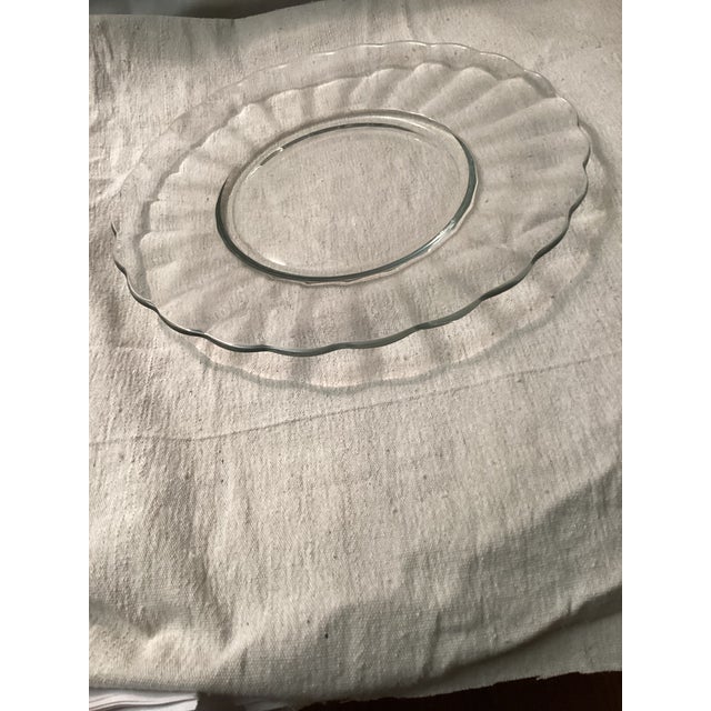This is a vintage clear glass TORTE platter featuring a scallop edge design. Perfect for serving pastries or desserts....
